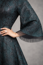 Green Jacquard gown with black accents and funnel sleeves